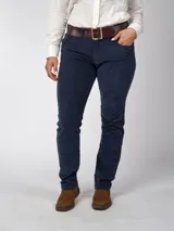 Pantalón de pana azul marino, de corte recto y calce ajustado, con cinco bolsillos y cinturón de cuero marrón.