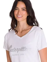 Remera de cuello en V, manga corta, color blanco con estampa metálica frontal de la marca Caterpillar.