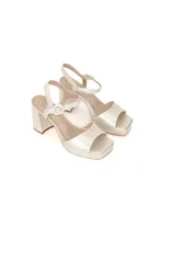 Sandalia de cuero con acabado perlado, diseño de plataforma y taco cuadrado. Presenta tiras anchas en el empeine y pulsera ajustable al tobillo con hebilla metálica.