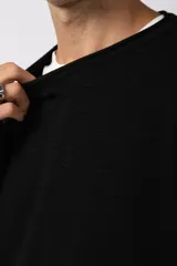 Sweater de punto liviano color negro con textura marcada, diseño de cuello redondo y calce holgado.
