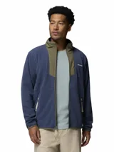 Campera de polar para hombre con cierre frontal completo. Presenta un diseño de bloques de color con cuerpo en azul y detalles en verde oliva en el cuello y la solapa central. Incluye bolsillos laterales con cierre y logo de la marca bordado en el pecho.