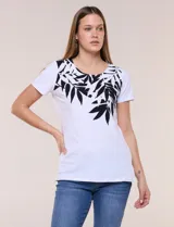 Remera de silueta recta confeccionada en algodón y elastano, de color blanco. Presenta escote redondo, mangas cortas, ruedo recto con tajos laterales y un diseño destacado en la pechera con aplique de piedras a tono.