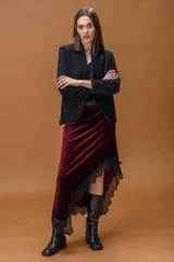 Chaqueta de corte entallado en color negro, confeccionada en un tejido suave con acabado ligeramente afelpado. Presenta un diseño minimalista sin botones, con cuello ligeramente elevado y mangas largas.