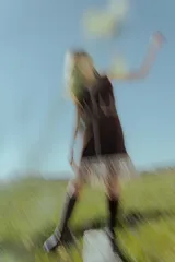 Vestido corto negro sin mangas, con escote en V y detalle de flecos en el ruedo. Presenta bordados en color blanco en el escote, los bolsillos y el centro del vestido.