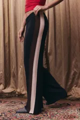 Pantalón tejido de corte recto y holgado, con cintura elástica. Presenta un diseño tricolor en los laterales con franjas verticales en negro, marrón y beige.