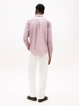 Camisa de hombre Tommy Hilfiger de manga larga, color rosa, confeccionada en algodón regenerativo de tejido dobby. Tiene cuello camisero clásico, cierre con botones, puños abotonados y logo de Tommy Hilfiger bordado en el pecho.