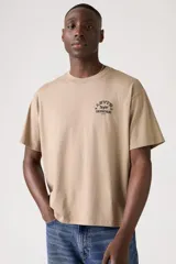 Remera Levi's color beige, de corte relajado y cropped, con cuello redondo y manga corta. Presenta un estampado frontal con el logo de la marca y la leyenda "Original Riveted 1873".