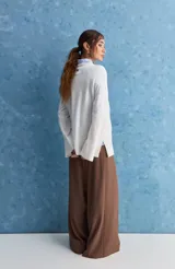 Sweater blanco de punto con diseño holgado, cuello redondo, mangas largas acampanadas y detalles de textura horizontal en el tejido.