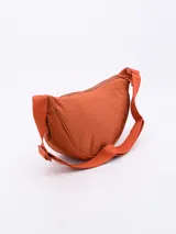 Morral tipo bandolera de diseño semicircular, confeccionado en tela técnica color rojo. Cuenta con cierre superior y correa ajustable al tono.