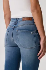 Pantalón jean de corte oxford, color blanco, con silueta ajustada en caderas y muslos y botamanga acampanada. Cuenta con bolsillos clásicos y costuras pespunteadas en contraste.