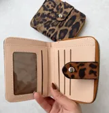 Billetera pequeña con cierre de cremallera y solapa con broche a presión.