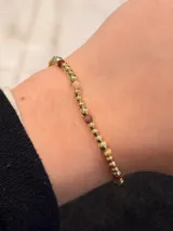 Pulsera elástica con baño de oro y cuentas de jaspe australiano en tonos tierra.