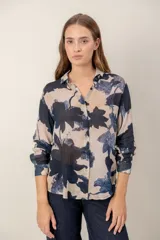 Camisa de manga larga con estampado de leopardo, cuello clásico y cierre frontal de botones. Presenta un corte holgado y puños abotonados.
