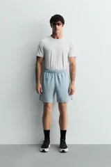 Pantalones deportivos cortos de tejido técnico ligero y elástico, con cintura elástica ajustable, bolsillos frontales y aberturas laterales en el bajo.