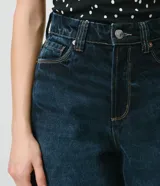 Bermuda long de jean azul con tiro alto, cintura con pasacintos, cierre con botón y cremallera, bolsillos funcionales y pespuntes en contraste.