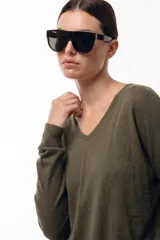 Sweater de punto color verde oliva, con cuello en V y mangas largas con puños acanalados. Presenta una silueta relajada y un diseño liso de tejido suave y liviano.