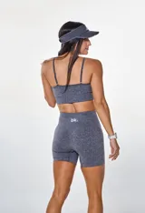 Conjunto deportivo compuesto por un top de breteles finos con logo estampado y un short ciclista de tiro alto, confeccionado en tejido de punto elástico gris jaspeado.