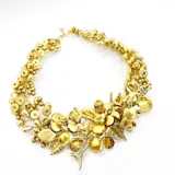 Collar corto dorado con cuentas y apliques de flores y hojas.