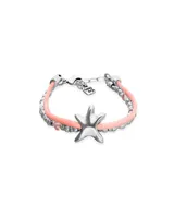 Pulsera de diseño artesanal con doble hilo de seda naranja, combinada con esferas plateadas y cristales facetados en tono naranja. Presenta un dije central en forma de estrella de mar en metal plateado y cierre de mosquetón con placa de marca.