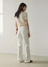 Pantalón wide leg de tiro medio confeccionado en denim de algodón, de color blanco, con trabillas para cinto y bolsillos de solapa delanteros.