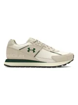 Championes Under Armour Essential Runner de estilo retro, confeccionados con una combinación de nailon ligero y revestimientos de gamuza. Presentan un diseño en tonos crema con detalles en verde oscuro, incluyendo el logo lateral y la entresuela. Cuentan con plantilla de espuma de lujo y suela de goma para mayor tracción.