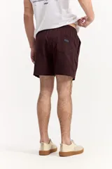 Short de baño de color marrón con textura en relieve, cintura elástica con cordón ajustable, bolsillos laterales y bolsillo trasero con detalle de la marca.