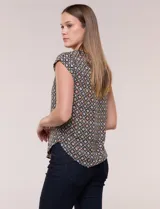 Blusa de gasa liviana de corte relajado, con estampado geométrico de rombos en tonos oscuros y rosados, escote redondo, mangas cortas y bolsillo frontal aplicado.