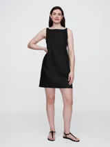 Vestido corto de lino color rojo tomate, con escote cuadrado y tirantes finos. Presenta un diseño de corte recto y holgado.