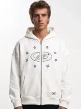Campera canguro blanca con cierre frontal, capucha y bolsillos tipo kankaro. Presenta un estampado frontal con un óvalo con texto cursiva rodeado de estrellas negras.