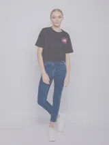 Pantalón de jean chupín azul con cuatro bolsillos, botón y cierre metálicos.