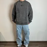 Jean cargo de corte baggy en color azul lavado, con múltiples bolsillos laterales tipo cargo y cierre frontal.