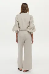 Pantalón de lino color beige, de corte ancho y relajado, con cintura alta y bolsillos laterales.