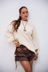 Sweater de punto color beige, con cuello redondo y mangas largas abullonadas, de corte holgado.