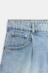 Shorts denim de tiro alto y corte relaxed, confeccionados en tejido vaquero celeste claro. Presentan trabillas en la cintura, diseño de cinco bolsillos, pliegues frontales y cierre con cremallera y botón metálico.
