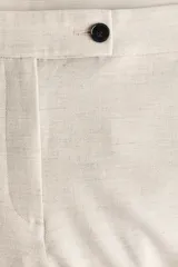 Pantalón tobillero de corte bootcut, color beige, con cintura estándar, raya marcada al frente y en la espalda, y cierre con pretina prolongada y botón.