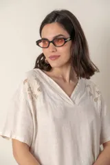 Blusa celeste de lino con escote en V, mangas cortas y detalle de bordado calado en el canesú.