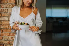 Camisón de satén elastizado color celeste, con escote en V con detalle de puntilla blanca y breteles finos cruzados en la espalda.