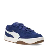 Championes urbanos Puma modelo Park Lifestyle Sk8 Sd, confeccionados en gamuza azul con la icónica franja lateral en blanco. Presentan una entresuela blanca y suela de goma color caramelo, ofreciendo un diseño inspirado en el skate.