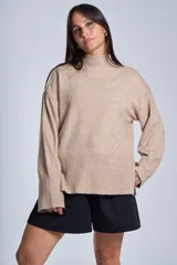 Sweater color crema de media polera, corte holgado y mangas largas. Tejido de punto con detalles acanalados en cuello, puños y ruedo.