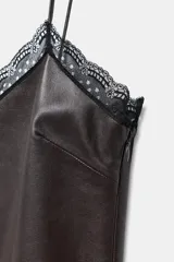 Top de tirantes finos confeccionado en piel 100%, con escote en pico adornado con encaje a contraste y paneles laterales de encaje negro.