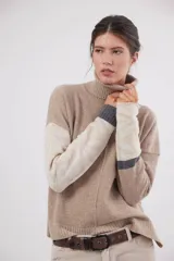 Polera de calce relajado confeccionada en lana, con cuello alto y mangas largas que presentan un diseño jacquard con motivos de arabescos y rayas en contraste. Incluye un pin bordado con el logo en la espalda.