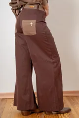 Pantalon de corte wide leg en color bordó, con cintura alta, cierre frontal con botón y bolsillos laterales.