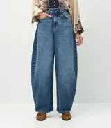 Pantalón de jean corte barrel, de tiro medio y piernas amplias con ruedo ligeramente ajustado. Cuenta con bolsillos funcionales, trabillas para cinturón y cierre frontal con botón y cremallera.