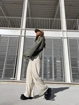 Poleron de tejido suave color verde, con cuello alto, corte holgado y mangas amplias con aberturas laterales en el ruedo.