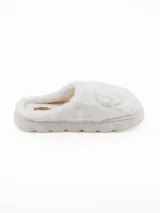 Pantuflas de peluche color blanco con diseño de corazón en relieve en la parte superior y suela de plataforma acolchada.