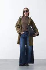 Polera de punto color marrón, con cuello alto y diseño de trenzas verticales en el frente y tejido acanalado en las mangas. Presenta mangas raglán y terminaciones acanaladas en puños y ruedo.