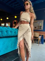 Pollera midi color beige con flecos en diagonal.