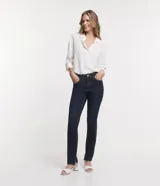 Pantalón de jean corte slim, color azul oscuro, con cierre de botón y cremallera, trabillas en la cintura y aberturas laterales en los bajos.