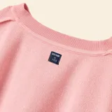 Buzo deportivo de corte cropped, color rosa, con cuello redondo, mangas largas con puños elásticos y abertura para el pulgar.