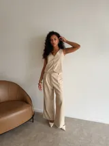 Chaleco de corte sastrero en tela tusor color beige con sutiles rayas verticales, escote en V y cierre frontal con botones al tono.